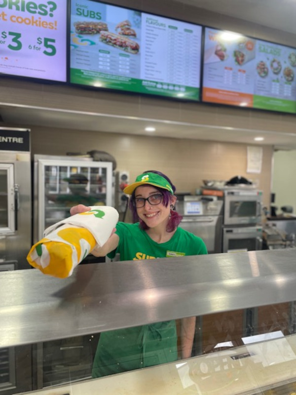 uLaunch - photo of Tiara handing someone a sub at a Subway counter