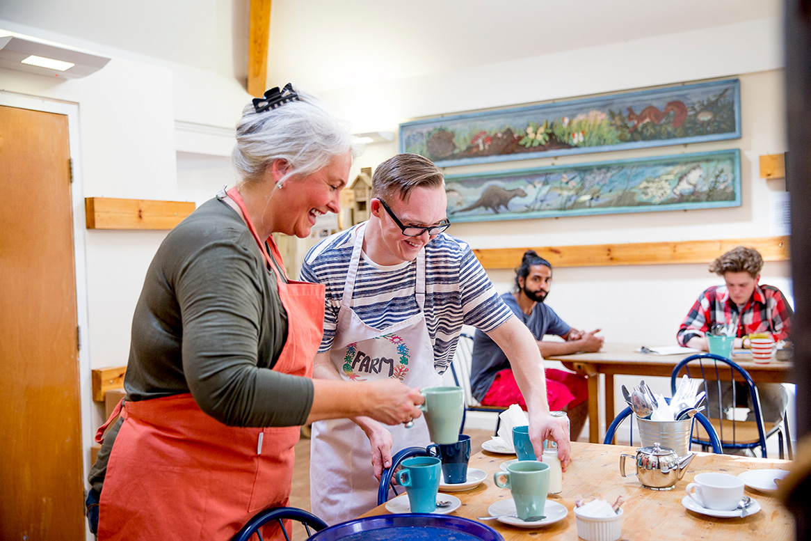 image of a cafe with a man and women clearing the table together