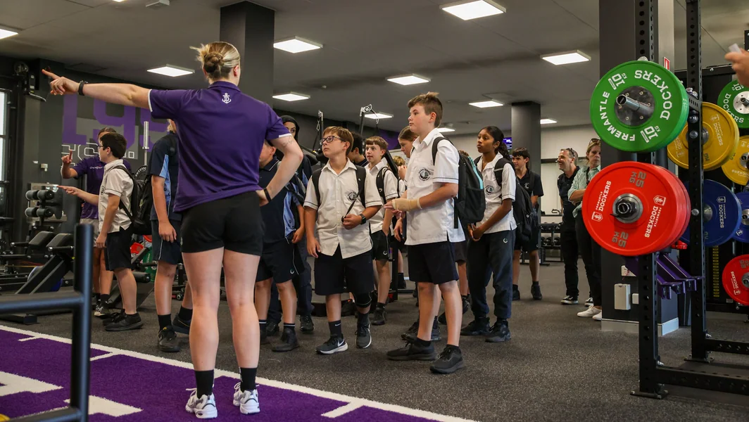 Students listening to a Get aHead mentor in a gym