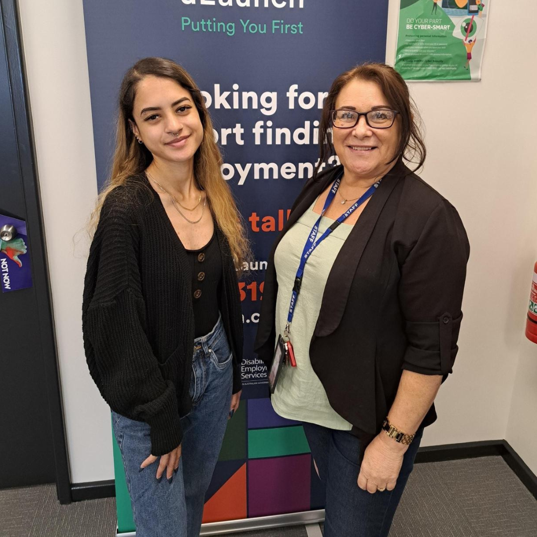 Maria and Lea standing in front of uLaunch pull up banner